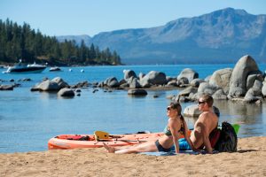 A couple relaxes on the beach of Lake Tahoe.